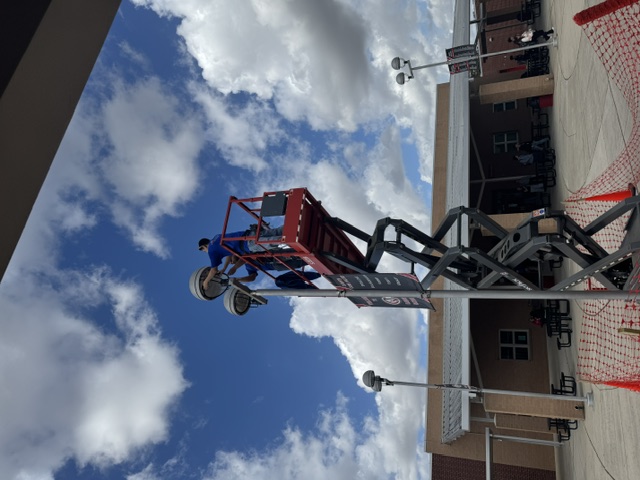 Vootu technicians installing exterior campus LED lighting from a lift at Carver Middle School